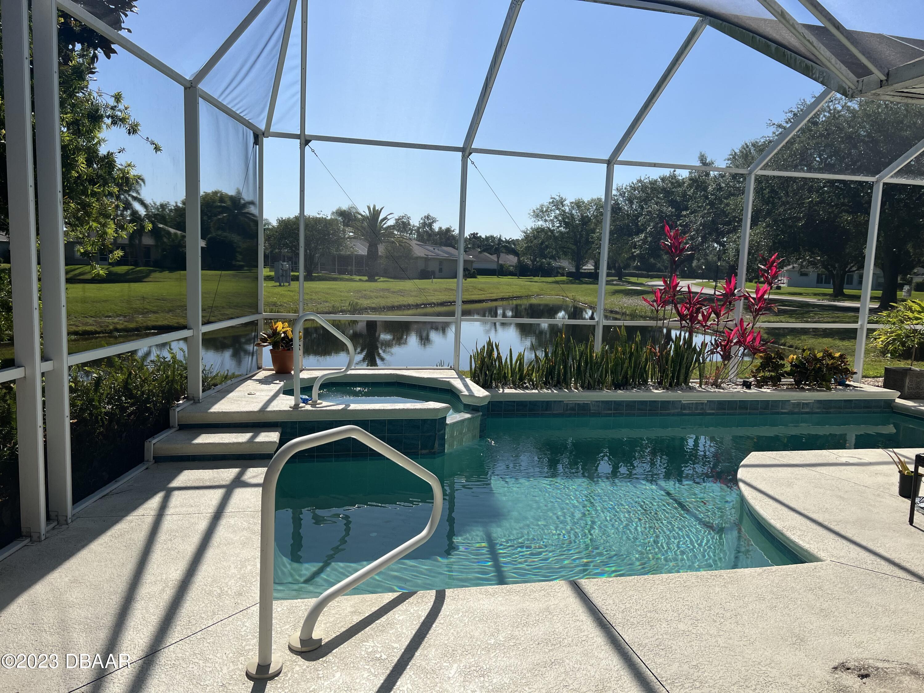 6129 Pheasant Ridge Drive Port Orange, FL 32128 - Photo 4 of 25 a view of a lake with a bench and wooden floor