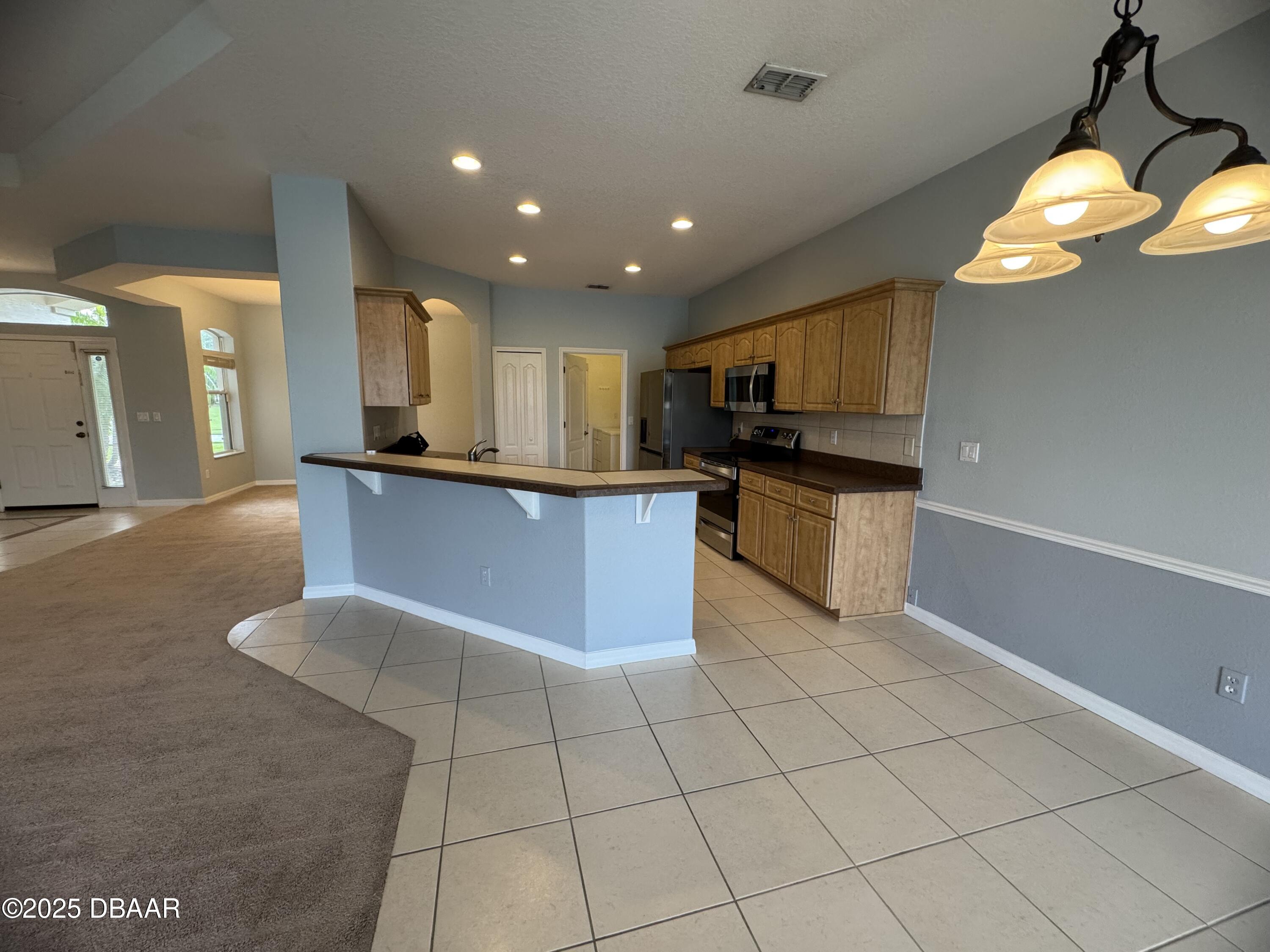 6129 Pheasant Ridge Drive Port Orange, FL 32128 - Photo 8 of 25 a kitchen with stainless steel appliances granite countertop a sink and a stove