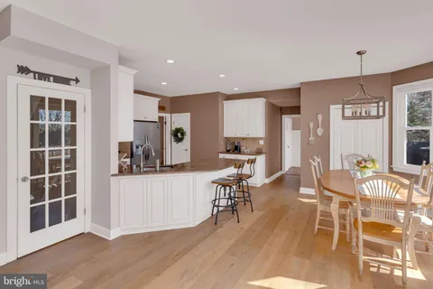 a living room with stainless steel appliances kitchen island granite countertop furniture and a wooden floor
