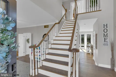 a view of staircase with lots of frames on wall and wooden floor