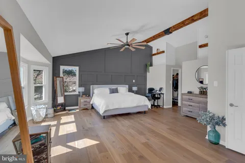 a view of a livingroom with furniture wooden floor and a ceiling fan