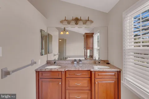a bathroom with a granite countertop sink and a bathtub
