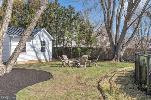 a view of a big house with a big yard and large trees