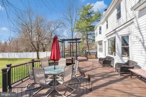 a view of a patio with a dining table and chairs with wooden floor and fence