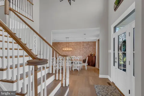 a dining room with wooden floor and stairs