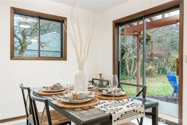 a view of a dining room with furniture large windows and wooden floor