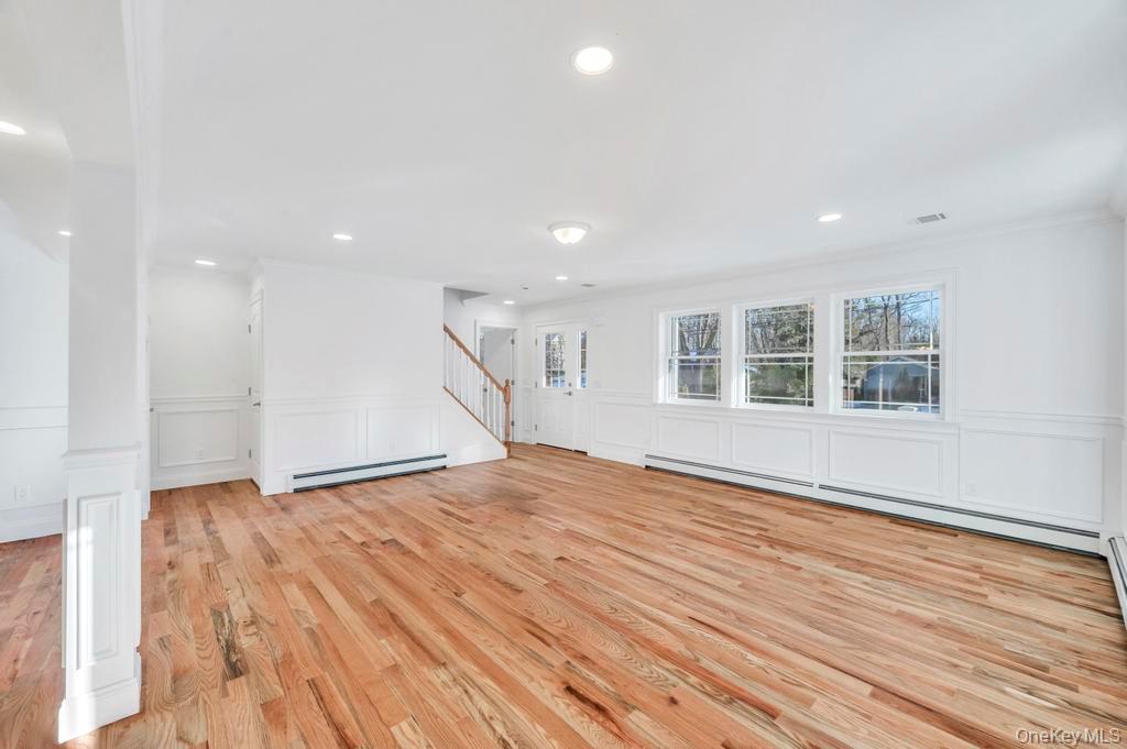 49 Barclay Road Mastic Beach, NY 11951 - Photo 12 of 33 a view of empty room with wooden floor and windows