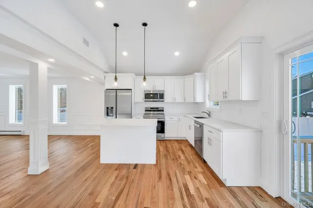 a kitchen with wooden floors and white cabinets