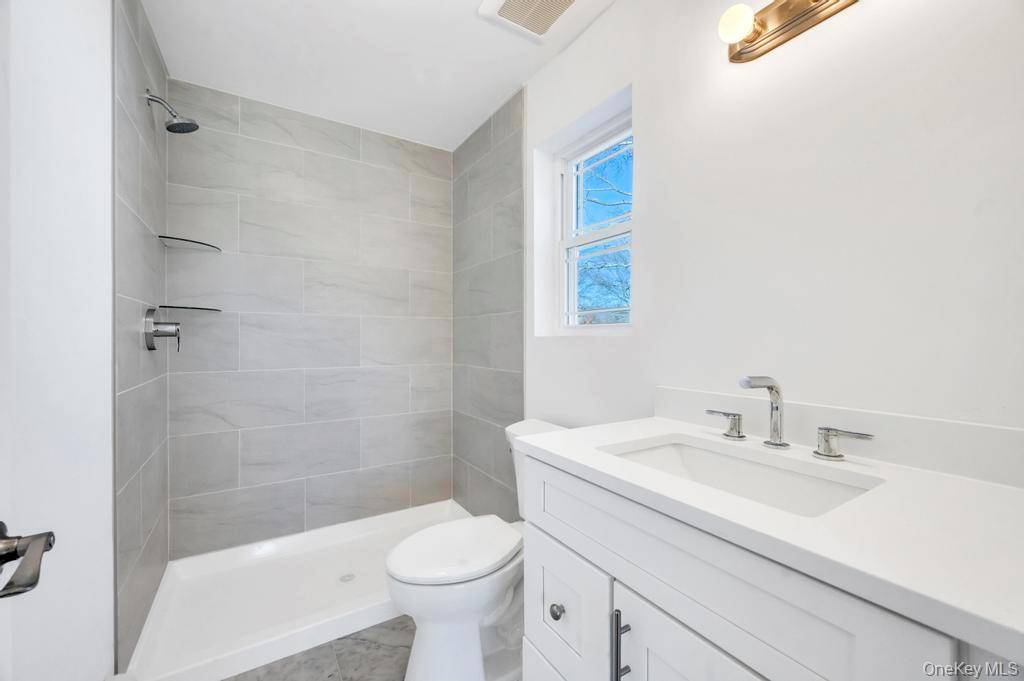 49 Barclay Road Mastic Beach, NY 11951 - Photo 22 of 33 a bathroom with a sink a toilet and shower