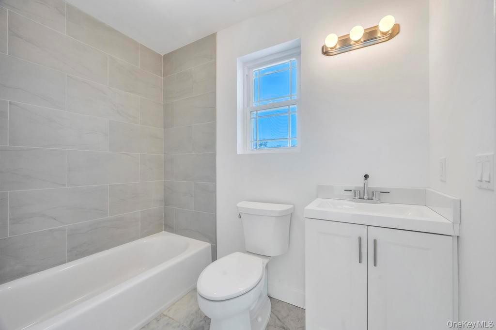 49 Barclay Road Mastic Beach, NY 11951 - Photo 29 of 33 a bathroom with a sink a toilet and bathtub