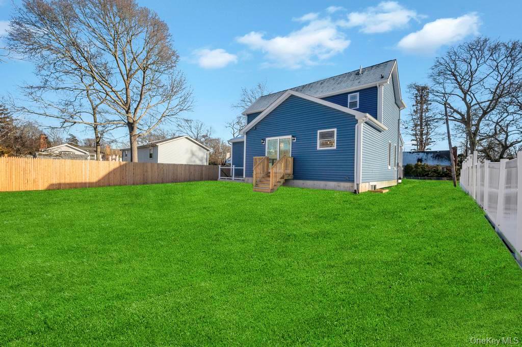 49 Barclay Road Mastic Beach, NY 11951 - Photo 7 of 33 a view of a yard in front of a house with large trees