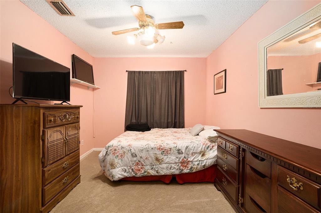 5960 Boyette Road Wesley Chapel, FL 33543 - Photo 19 of 32 a bedroom with a bed and a flat screen tv