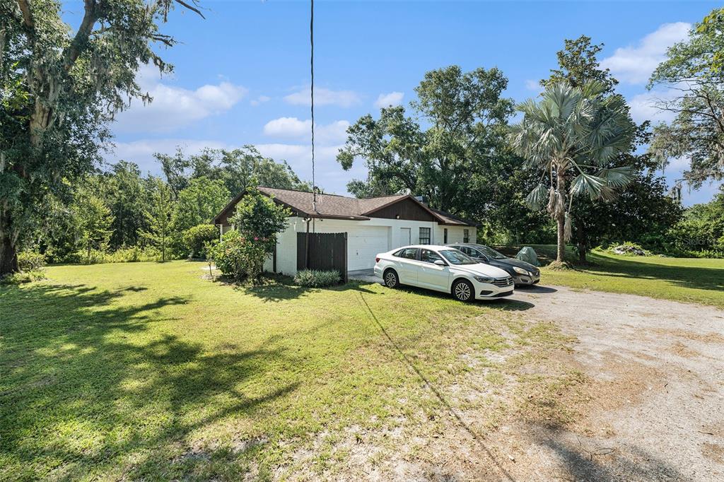 5960 Boyette Road Wesley Chapel, FL 33543 - Photo 24 of 32 a view of a house with a yard and garage