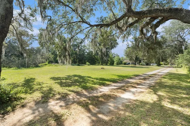 a view of yard with swimming pool and trees