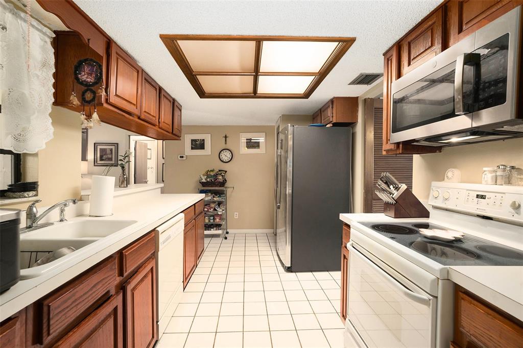 5960 Boyette Road Wesley Chapel, FL 33543 - Photo 9 of 32 a kitchen with stainless steel appliances granite countertop a sink stove and refrigerator