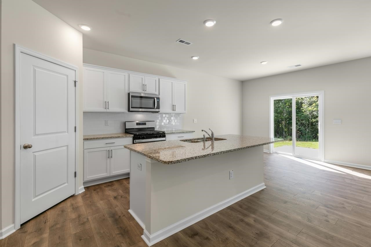 2129 Clydesmill Road Fayetteville, NC 28314 - Photo 12 of 37 a kitchen with kitchen island a sink stainless steel appliances and cabinets