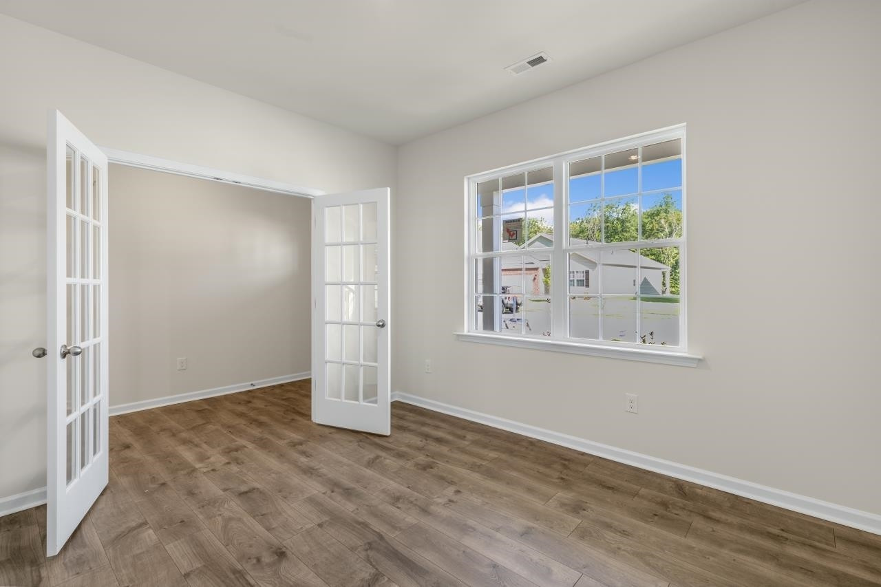 2129 Clydesmill Road Fayetteville, NC 28314 - Photo 14 of 37 an empty room with wooden floor and windows