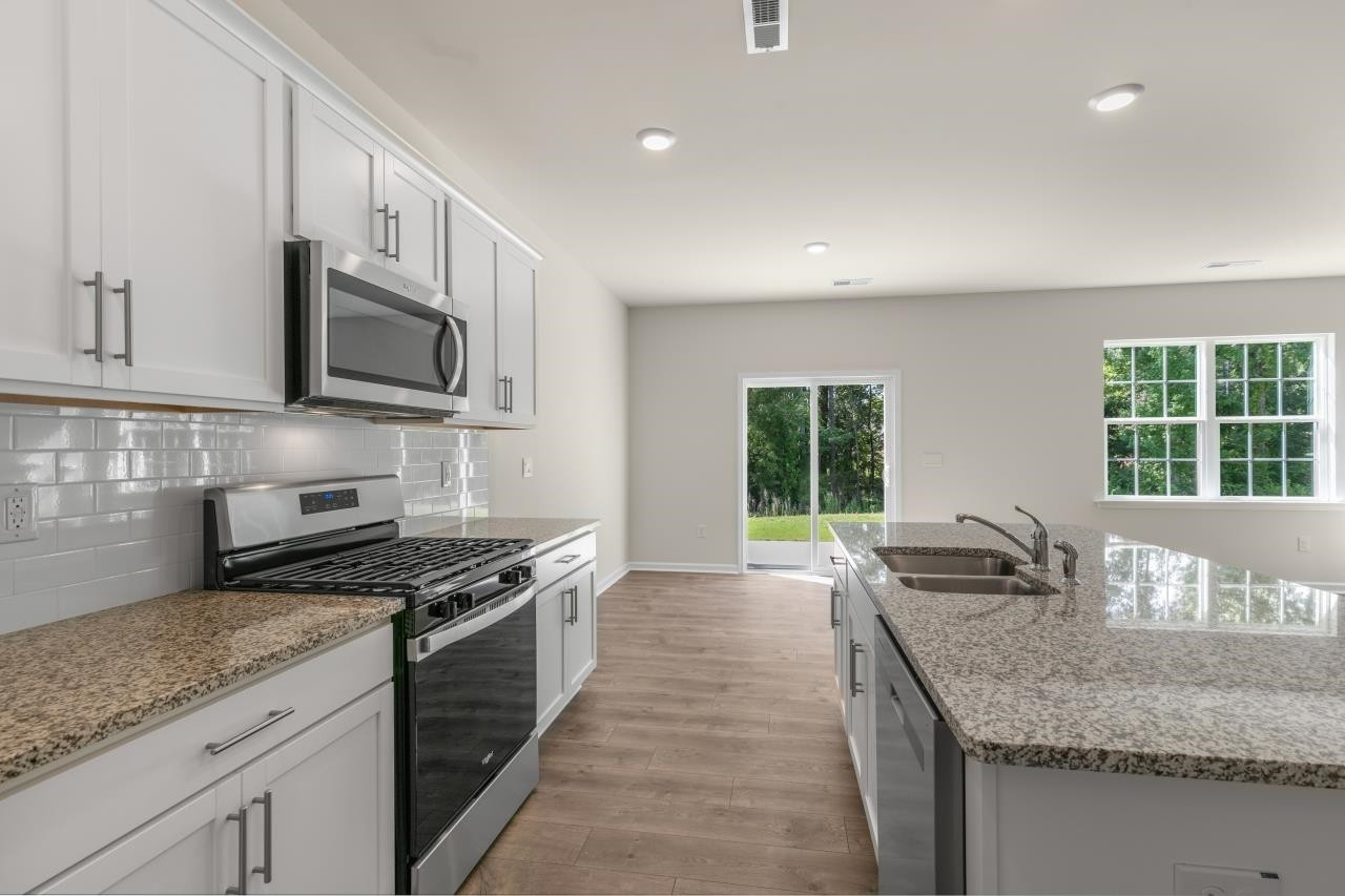 2129 Clydesmill Road Fayetteville, NC 28314 - Photo 17 of 37 a kitchen with granite countertop a sink a counter space appliances and cabinets