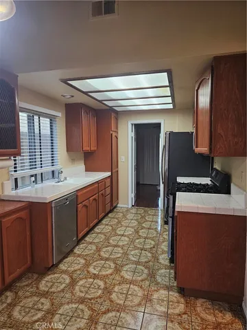a large kitchen with stainless steel appliances granite countertop a sink and cabinets
