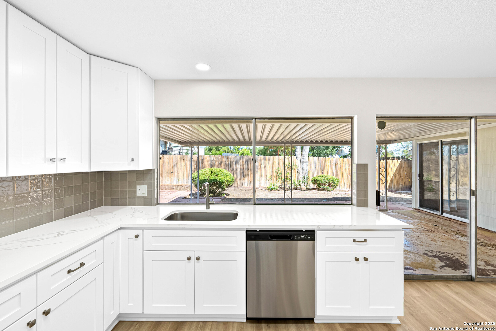 1106 Rio Linda Street San Antonio, TX 78245 - Photo 5 of 48 a kitchen with granite countertop white cabinets white appliances and a wide window