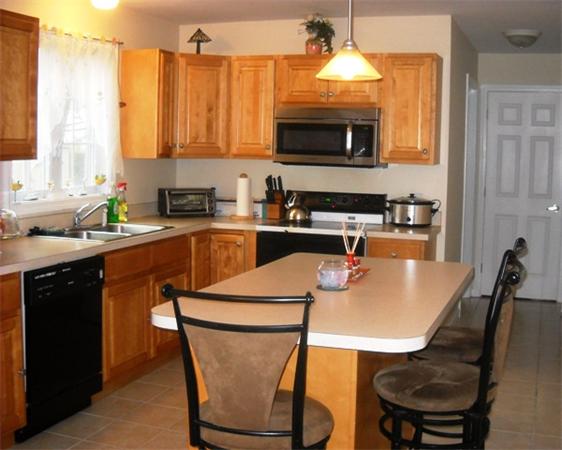 157 Cloran Street Springfield, MA 01109 - Photo 6 of 15 a kitchen with stainless steel appliances a stove a sink a microwave a dining table and chairs