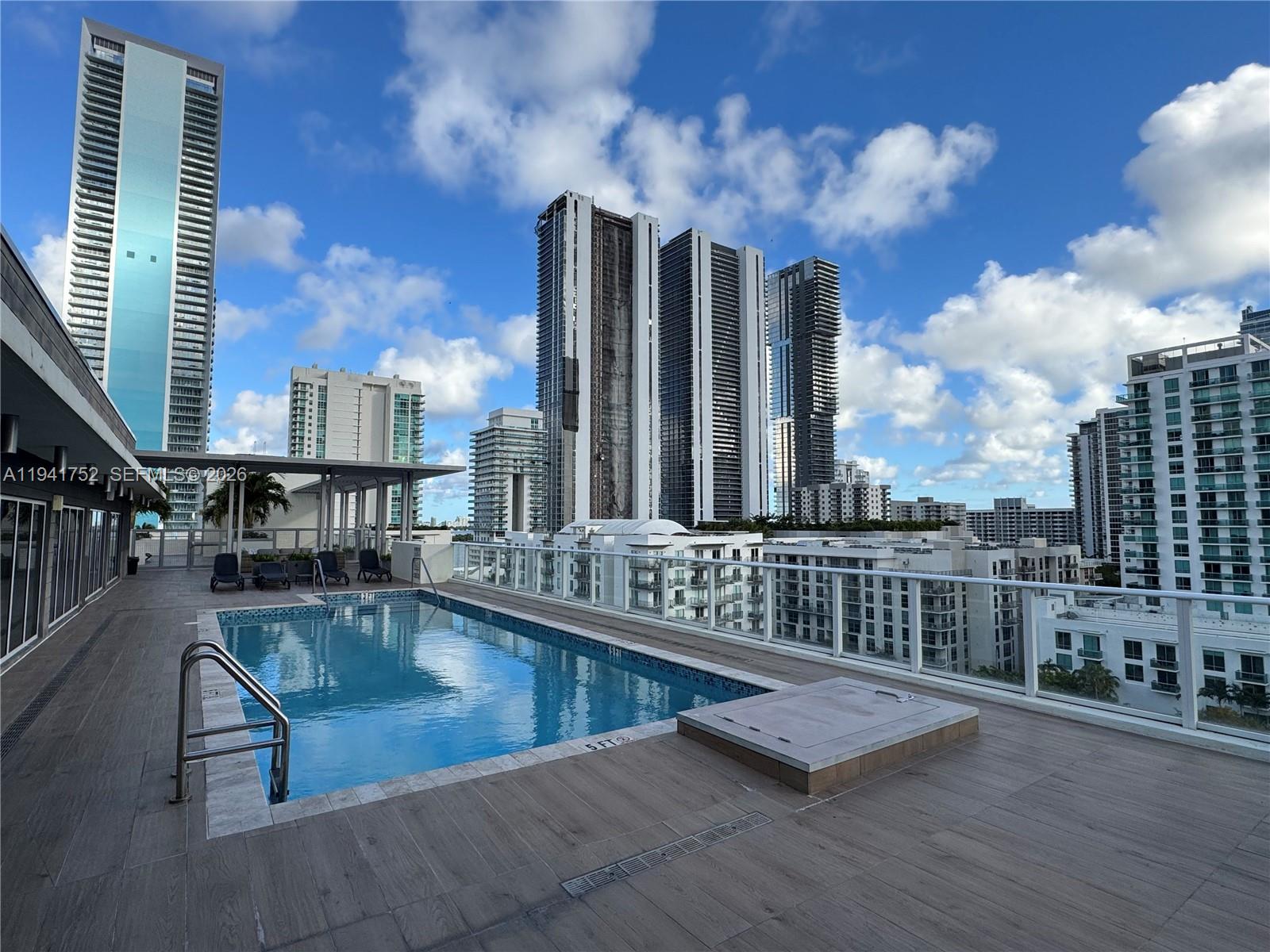 321 Northeast 26th Street, Unit 615 Miami, FL 33137 - Photo 2 of 22 a view of a swimming pool with a chair and tables