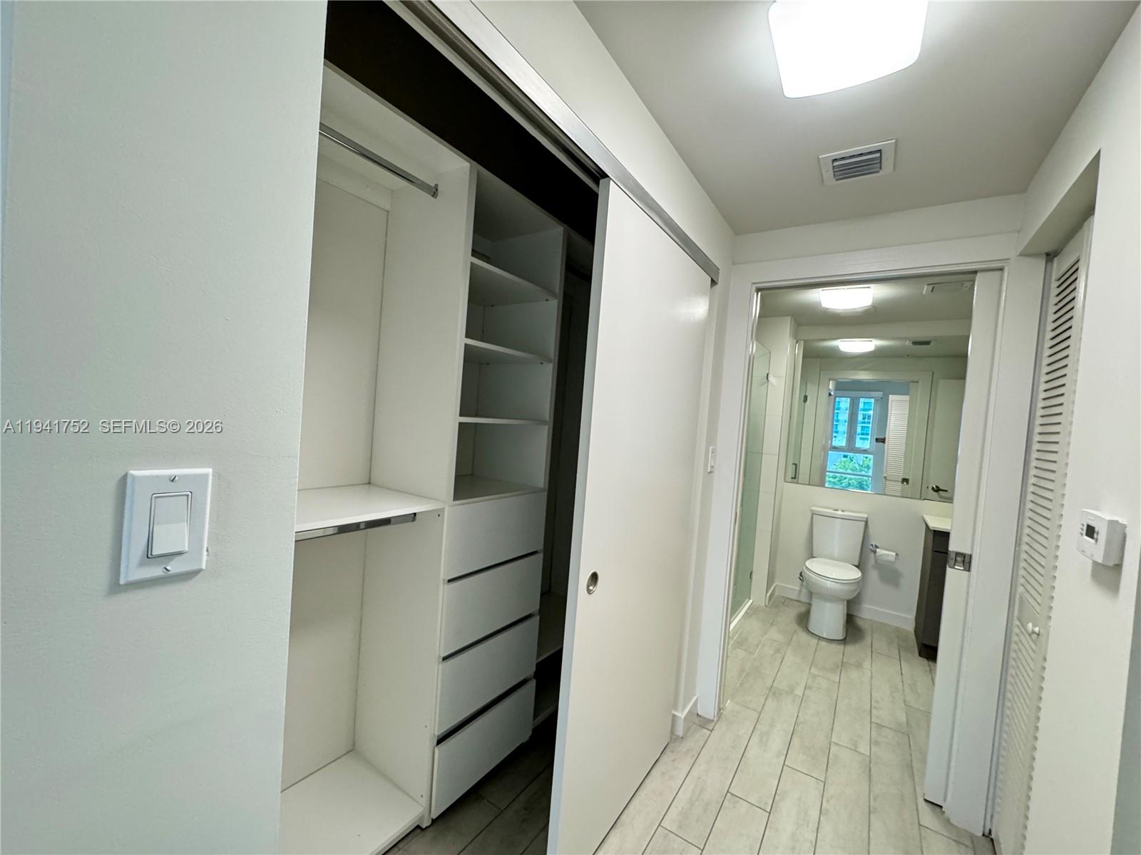 321 Northeast 26th Street, Unit 615 Miami, FL 33137 - Photo 7 of 22 a view of a hallway with wooden floor and a bathroom