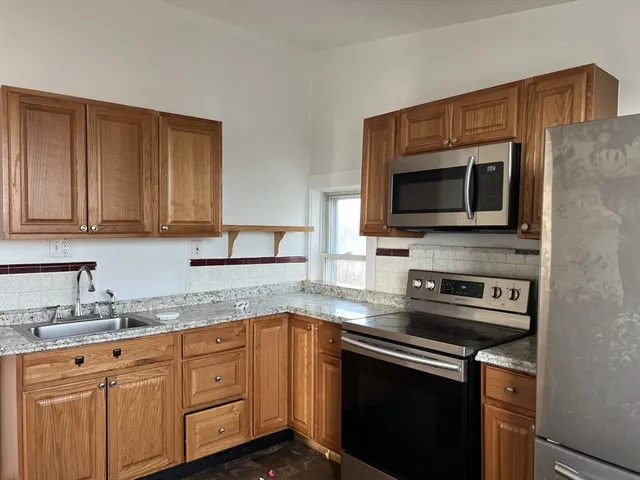 a kitchen with stainless steel appliances granite countertop a sink stove and microwave