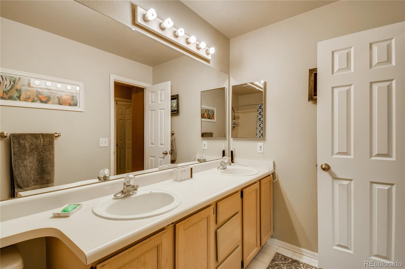 9879 Concord Court Highlands Ranch, CO 80130 - Photo 20 of 36 a bathroom with a sink double vanity and a mirror