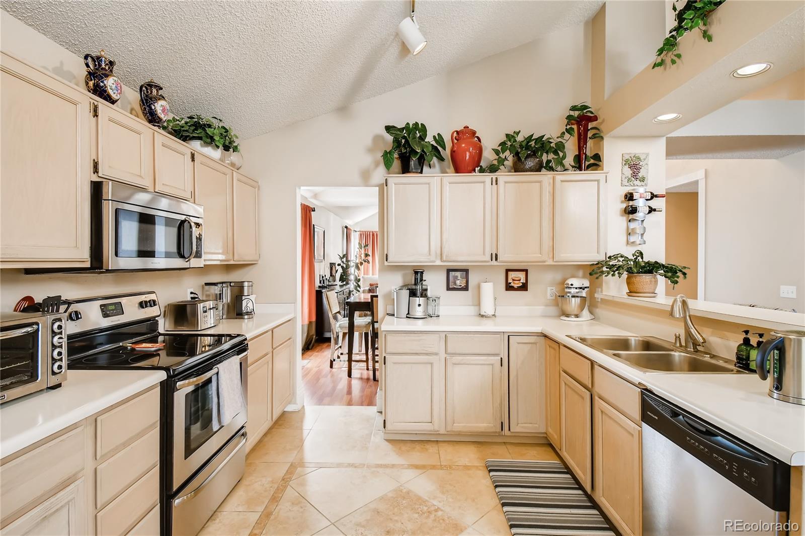 9879 Concord Court Highlands Ranch, CO 80130 - Photo 7 of 36 a kitchen with white cabinets and appliances