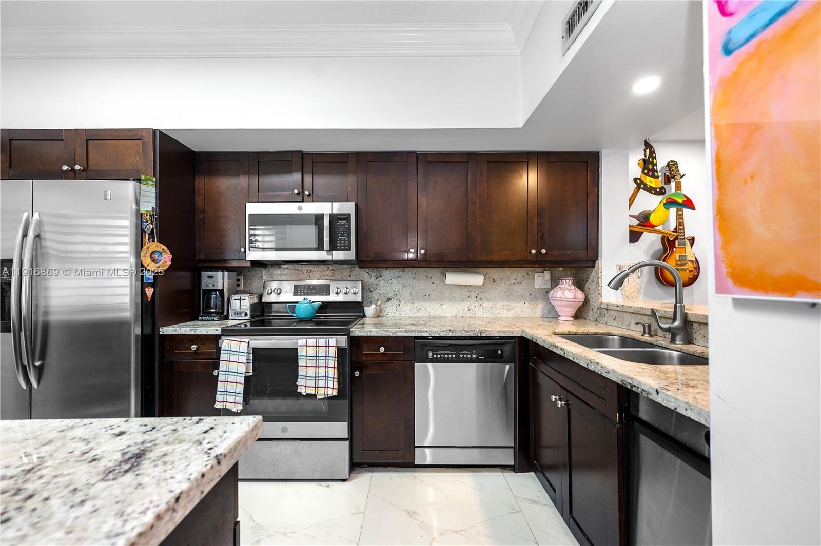 9985 Southwest 118th Place Miami, FL 33186 - Photo 7 of 30 a kitchen with stainless steel appliances granite countertop a sink stove and refrigerator