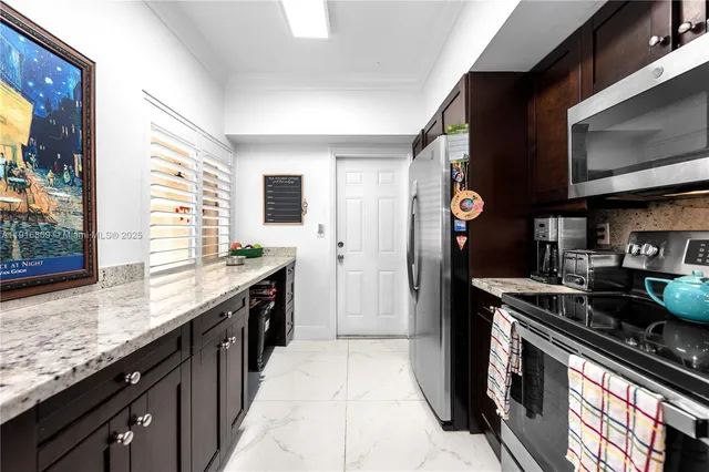 a kitchen with stainless steel appliances granite countertop a stove a sink and a microwave