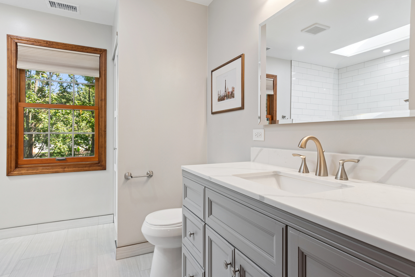 2230 Keim Road Naperville, IL 60565 - Photo 17 of 33 a bathroom with a toilet a sink a mirror and a window