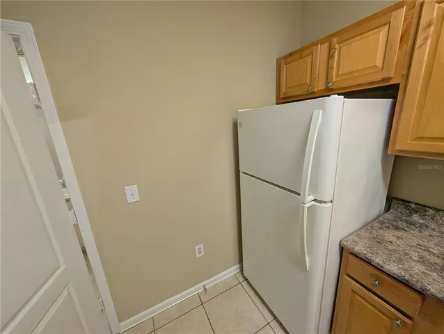 a white refrigerator freezer and a stove sitting inside of a kitchen
