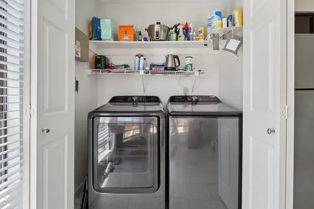 a utility room with lots of clutter and cabinets