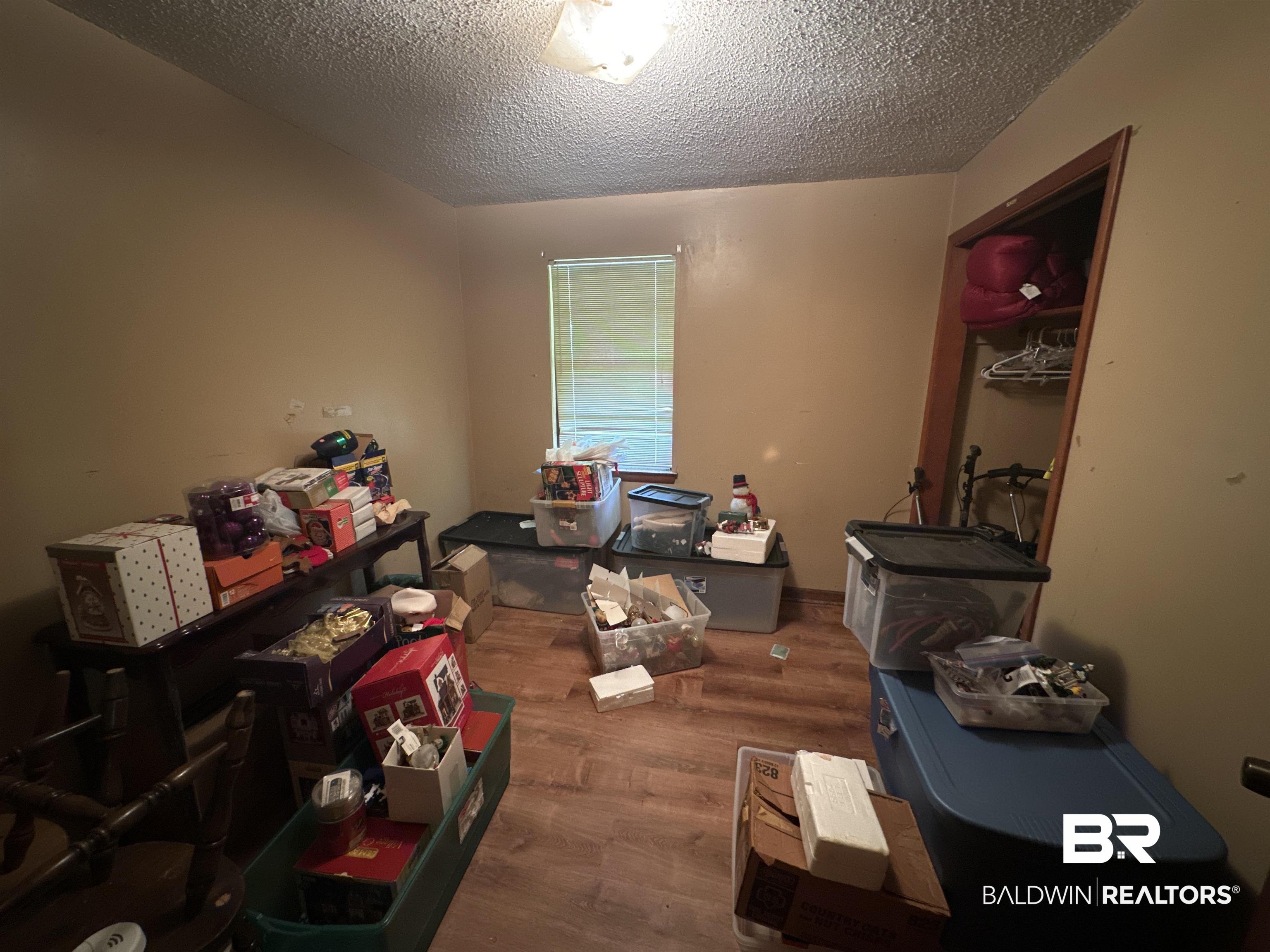 9520 C Four Mile Road Irvington, AL 36544 - Photo 17 of 32 Misc room featuring hardwood / wood-style floors and a textured ceiling