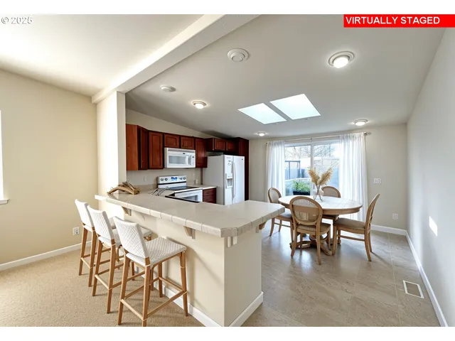 a kitchen with stainless steel appliances kitchen island granite countertop a sink stove and refrigerator