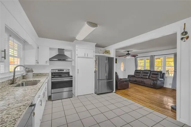 a kitchen with granite countertop a refrigerator and a stove top oven