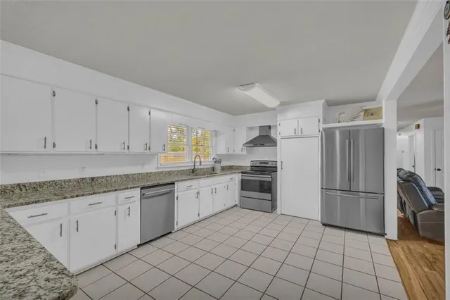 a kitchen with granite countertop white cabinets and stainless steel appliances