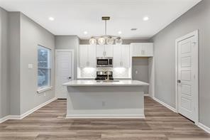 6814 Dumble Street, Unit A Houston, TX 77021 - Photo 7 of 22 a kitchen with kitchen island granite countertop a stove and a wooden floors