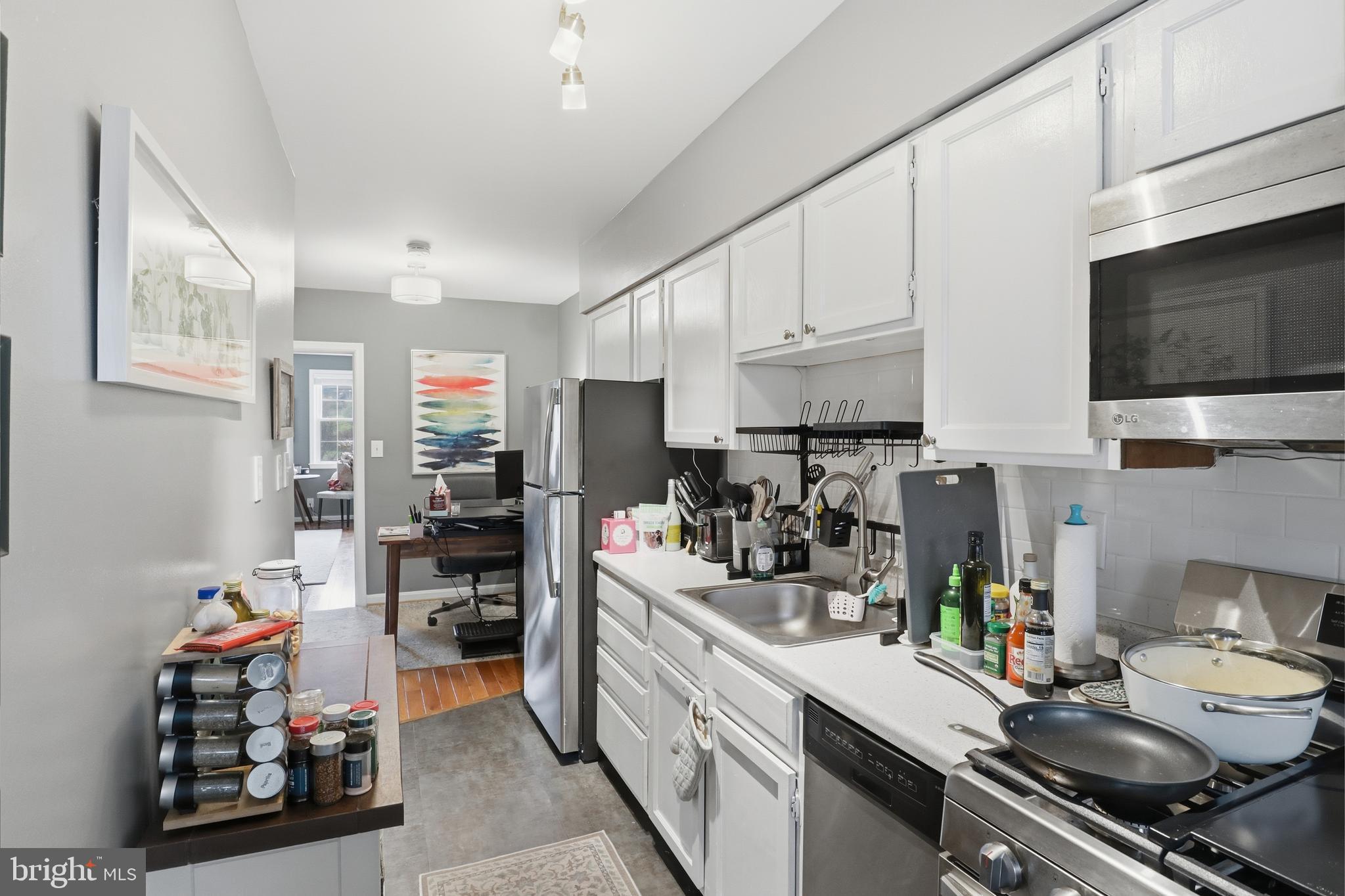7 Russell Road, Unit D Alexandria, VA 22301 - Photo 12 of 27 a kitchen with stainless steel appliances a stove a sink a refrigerator cabinets and wooden floor