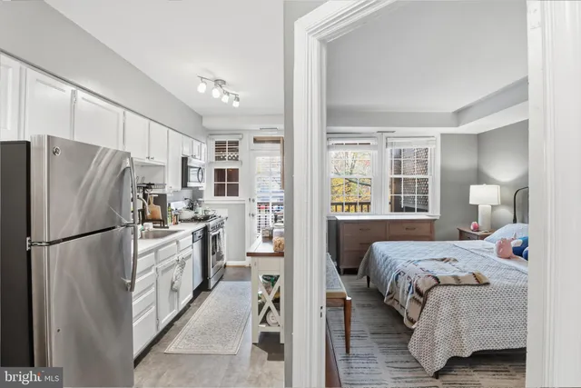 a kitchen with a refrigerator a stove top oven a sink and cabinets