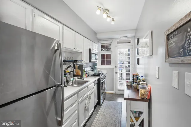 a kitchen with stainless steel appliances granite countertop a refrigerator a stove and a sink