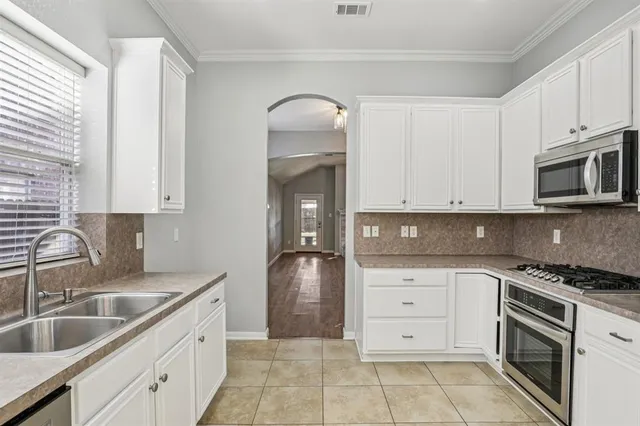a kitchen with granite countertop a sink stove and cabinets