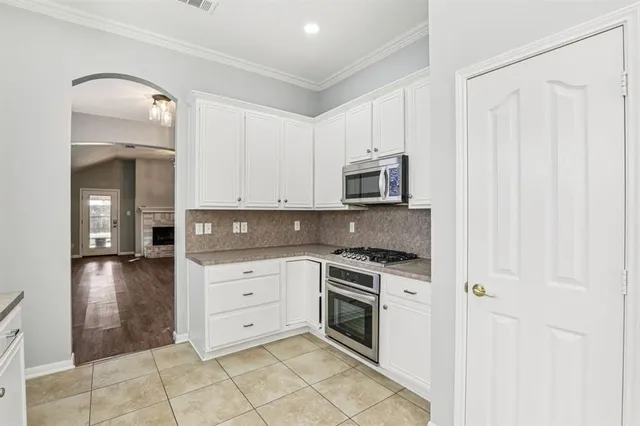 a kitchen with white cabinets and appliances