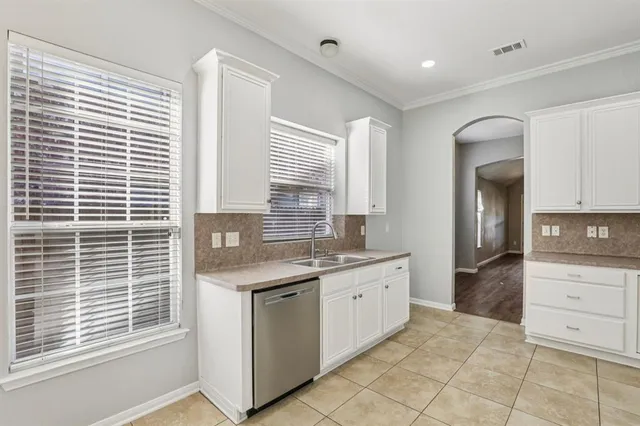 a kitchen with a sink window and cabinets