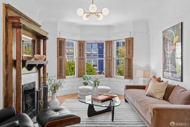 a living room with furniture fireplace and a large window