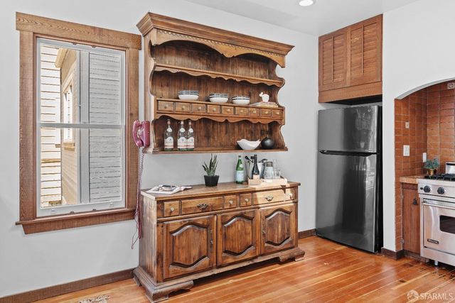 a kitchen with stainless steel appliances granite countertop a refrigerator and a wooden floors