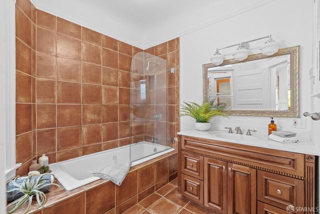 a bathroom with a tub sink and mirror