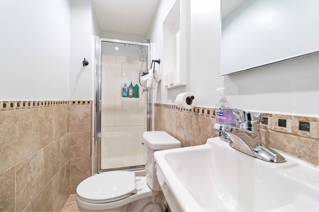 21 A Stowe Road, Unit A Southborough, MA 01772 - Photo 19 of 24 a bathroom with a sink a toilet and shower